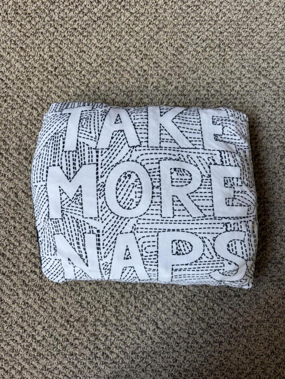 white and black "Take More Naps" pillow with a geometric pattern
